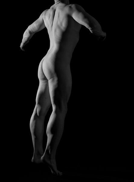Male nude figure against black